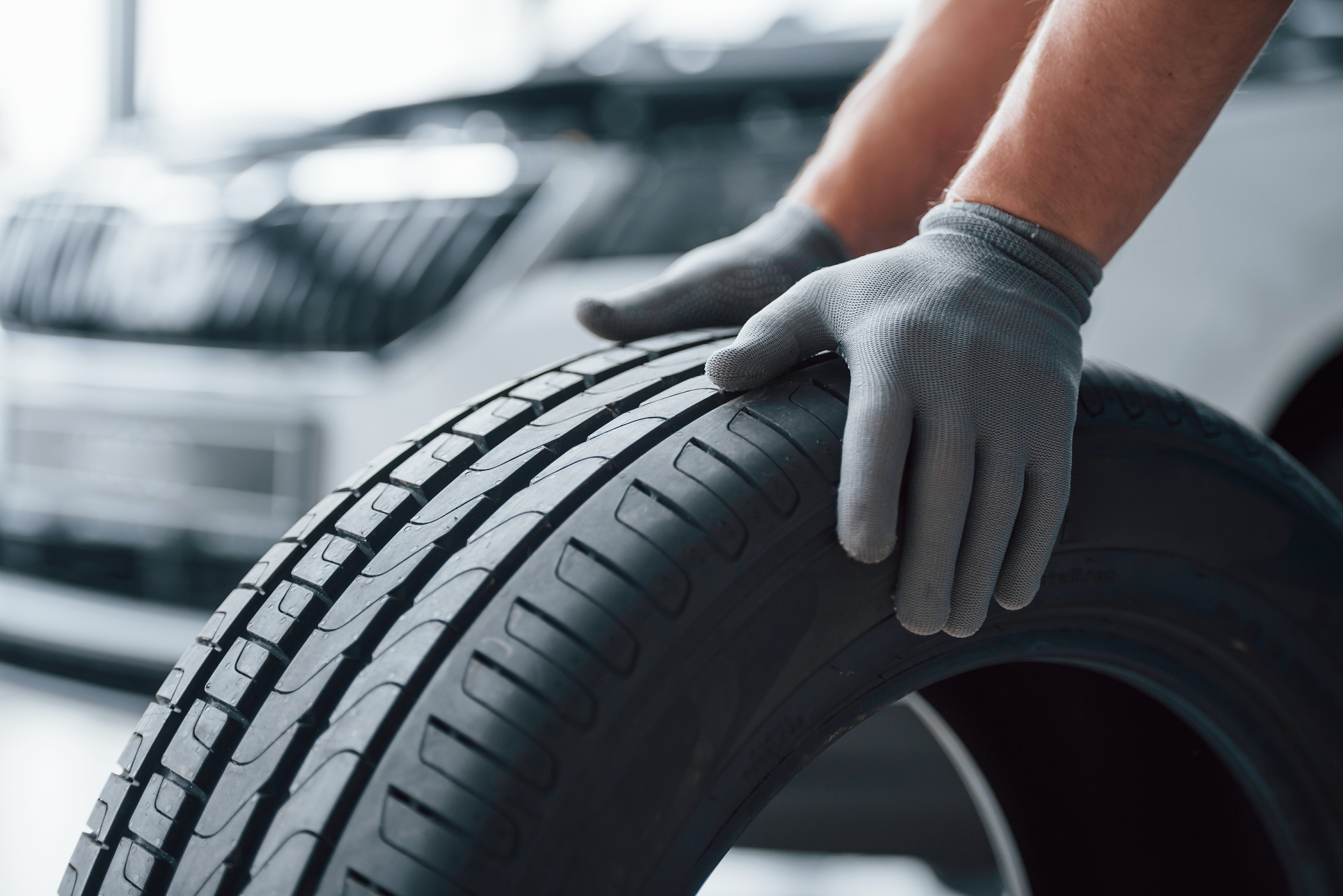 nur-haende-mechaniker-haelt-einen-reifen-in-der-reparaturwerkstatt-austausch-von-winter-und-sommerreifen